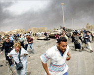 Reporters flee from a wrecked tank as US jets fly overhead