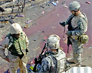 US soldiers inspect the blast site in Baquba that killed 16 people
