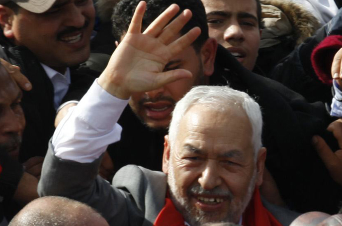 Sheikh Rachid Ghannouchi, head of the Ennahda movement, waves to supporters upon his arrival in Tunis