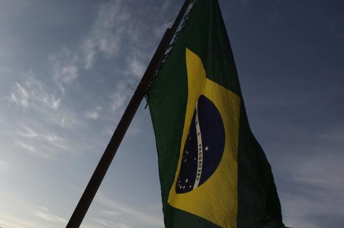 A resident holds a Brazilian flag at Copacabana beach in Rio de Janeiro