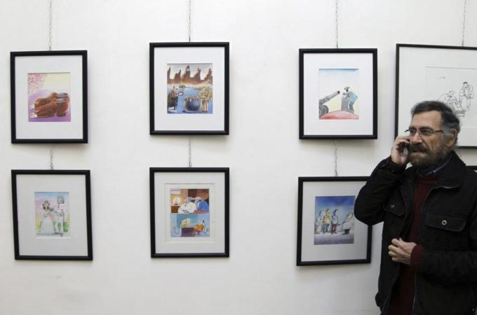 Syrian cartoonist Ferzat, speaks on his mobile phone at his art gallery, which was opened recently, in Damascus