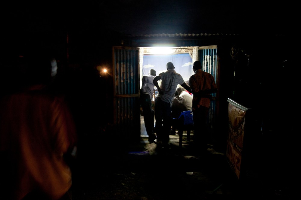 Kisumu residents watch the presidential debate in a barbershop. Kenya(***)s third largest city, the stronghold of candidate
Raila Odinga, erupted in violence after it was announced Odinga had lost the 2007 vote.