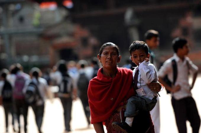 A Nepalese woman carries her child back
