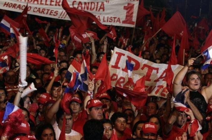 Supporters of Paraguayan presidential candidate Horacio Cartes of the Colorado Party hold banners during his campaign visit to the city of Capiata