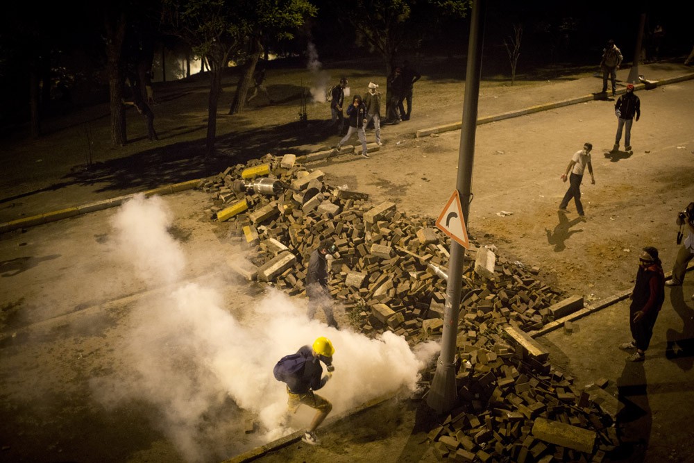 A protester runs away from tear gas during clashes on the road between Taksim square and Beshiktash stadium.