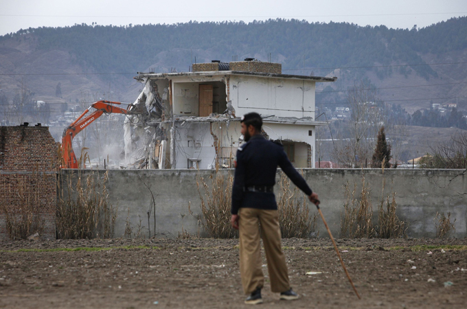 A policeman looks on as the building where al Qaeda leader Osama bin Laden was killed is demolished in Abbottabad