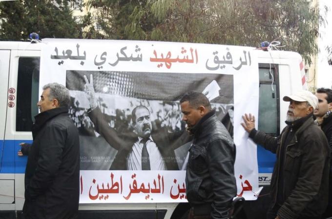 Men walk beside the ambulance carrying the coffin of assassinated prominent Tunisian opposition politician Chokri Belaid in Tunis