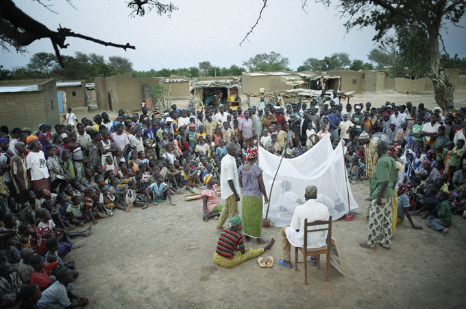 A theatre company explains the importance of using long-lasting insecticide-treated bed nets in the remote villages of Burkina Faso. Many villagers go to a traditional doctor to treat it. Most do not