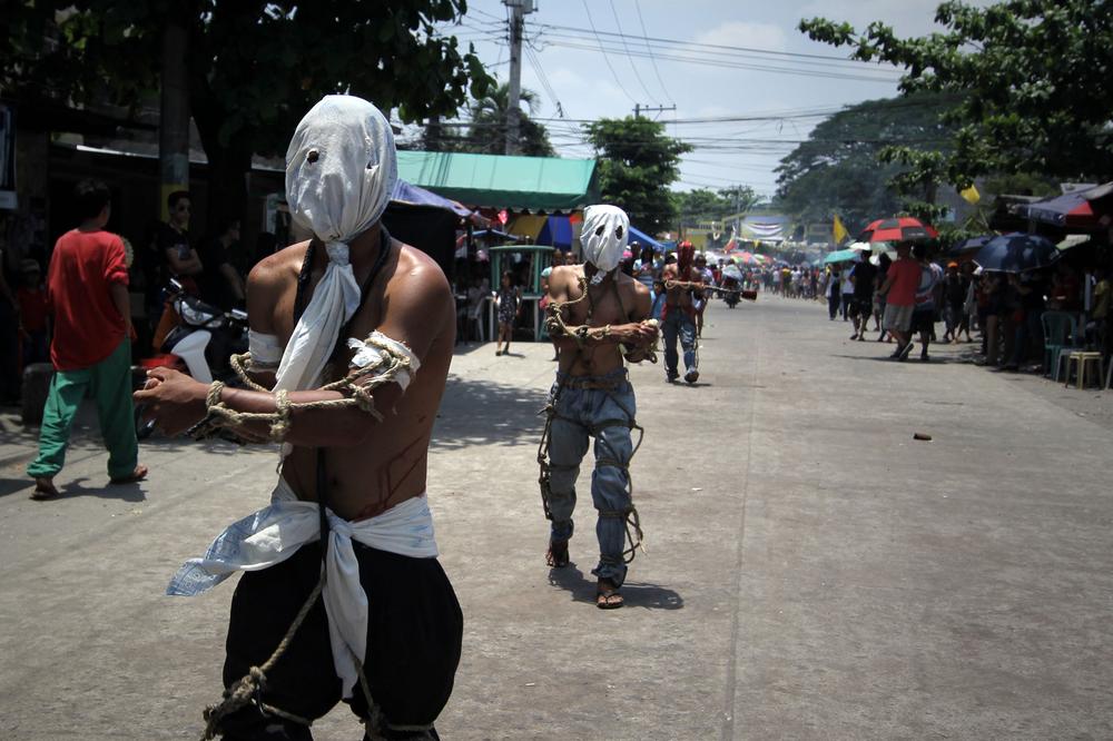 <p>Hooded penitents, barefoot and tied with homemade whips, flagellate themselves as part of an annual Easter tradition in the village of Lourdes.</p>