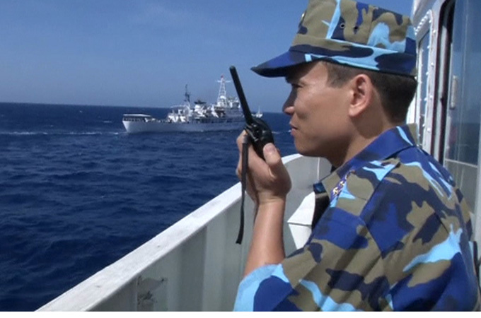 A Vietnamese Coast Guard officer monitors Chinese ships in the South China Sea [Reuters]
