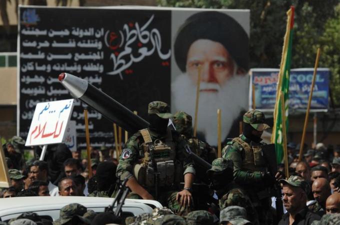 Iraqis loyal to cleric Moqtada al-Sadr vow to fight ISIL in a show of strength in a military parade [Getty]
