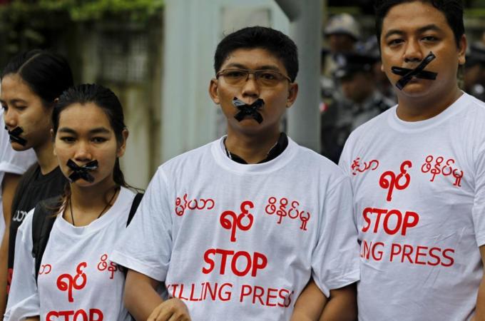 Myanmar journalists wear T-shirts with a slogan reading, 'Stop killing press' and tape over their mouths to protest against their jailed colleagues near the Myanmar Peace Center on July 12 [EPA]