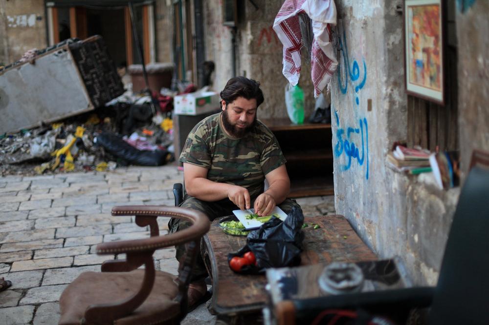 <p>A Free Syrian Army fighter prepares food to break his daily fast during the Islamic holy month of Ramadan.</p>