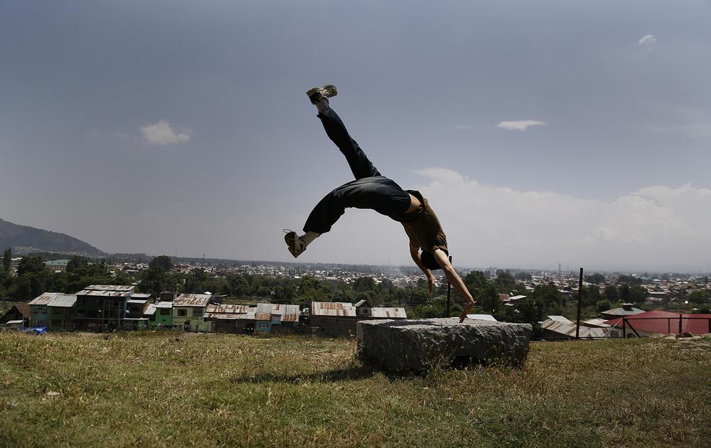 <p>Traceur Zahid performs his favourite move at his favourite practice place outside Srinagar. The old city can be seen in the background.</p>