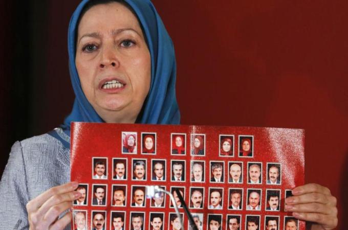 Maryam Rajavi, president-elect of the National Council of Resistance of Iran, shows a banner with pictures of Iranian dissidents killed in Camp Ashraf in Iraq [Reuters]