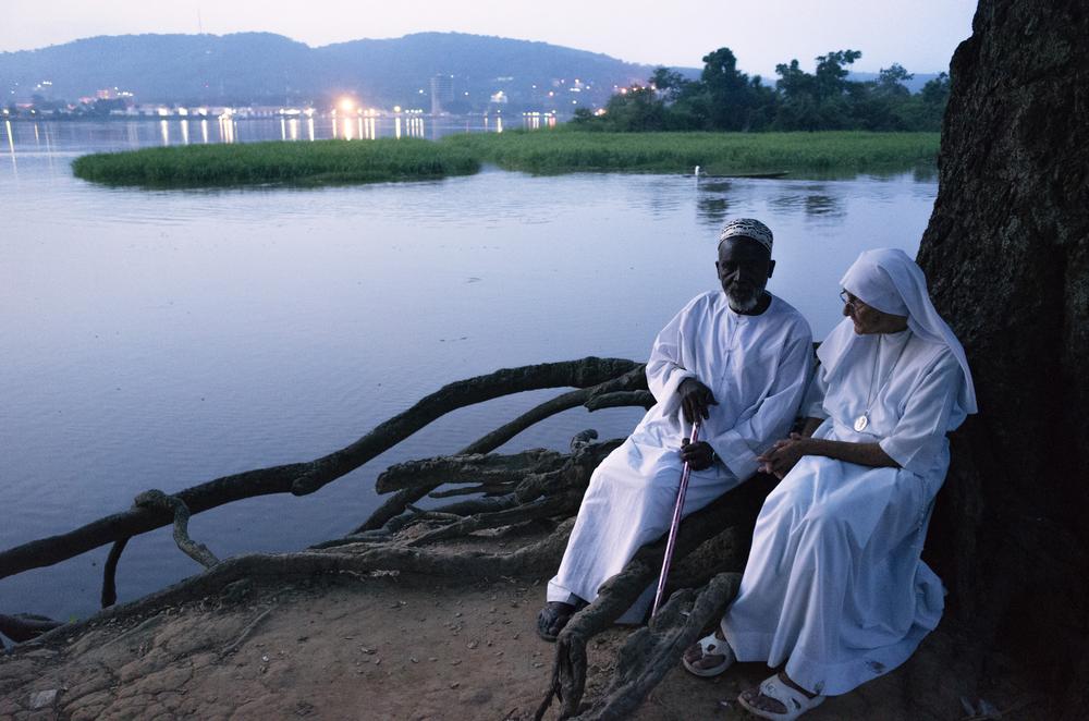 <p>Imam Moussa Bawa, 72, and Sister Maria Concetta, 80, converse on the banks of the Oubangi River in Zongo, DRC. The two religious leaders attempt to heal the wounds that have divided the Christian and Muslim communities in Central Africa Republic. </p>