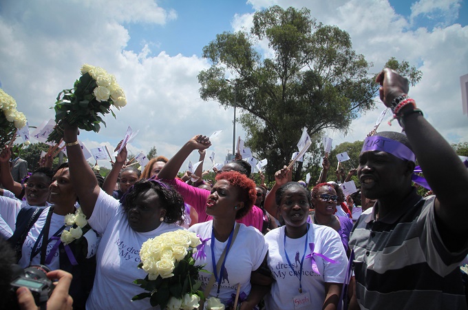 Women and men march to protest the stripping of a woman for wearing a miniskirt [Emily H Johnson/Al Jazeera]