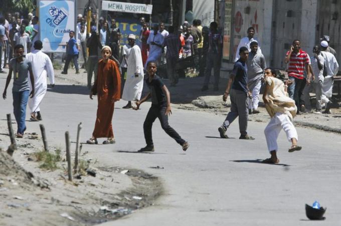 Kenyan youths throw rocks at police where a slain Muslim cleric used to preach in Mombasa [EPA]