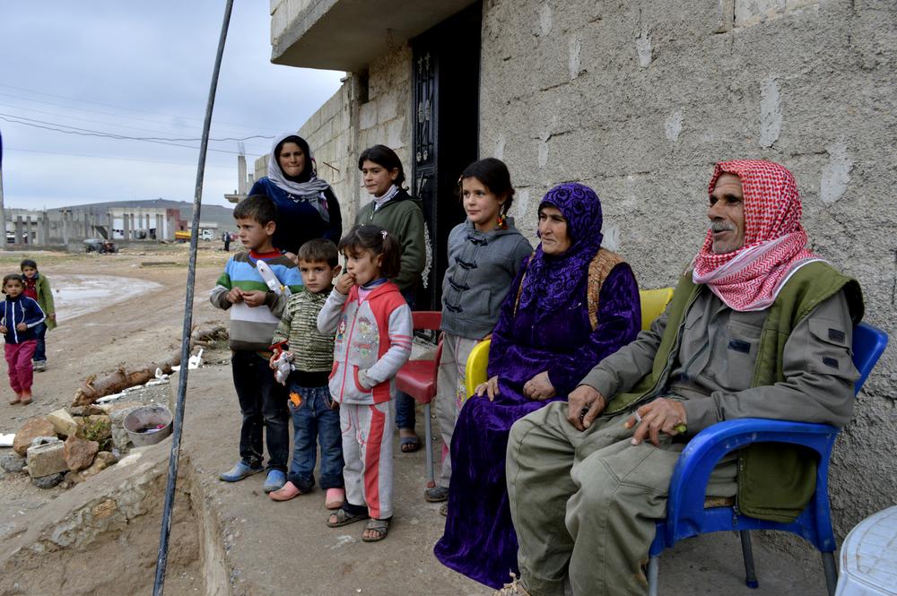 <p>Aladdin Abdo, 64, and his wife Amish Ahmed, 55, sit in front of their son(***)s house in Kobane surrounded by their children and grandchildren. Abdo is now a member of the Kurdish force in the besieged town.</p>