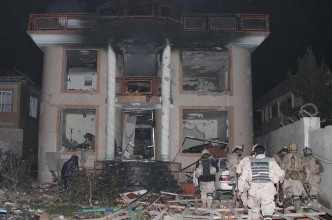 Afghan security personnel inspect the destroyed guesthouse of foreign aid workers in Kabul [Getty]
