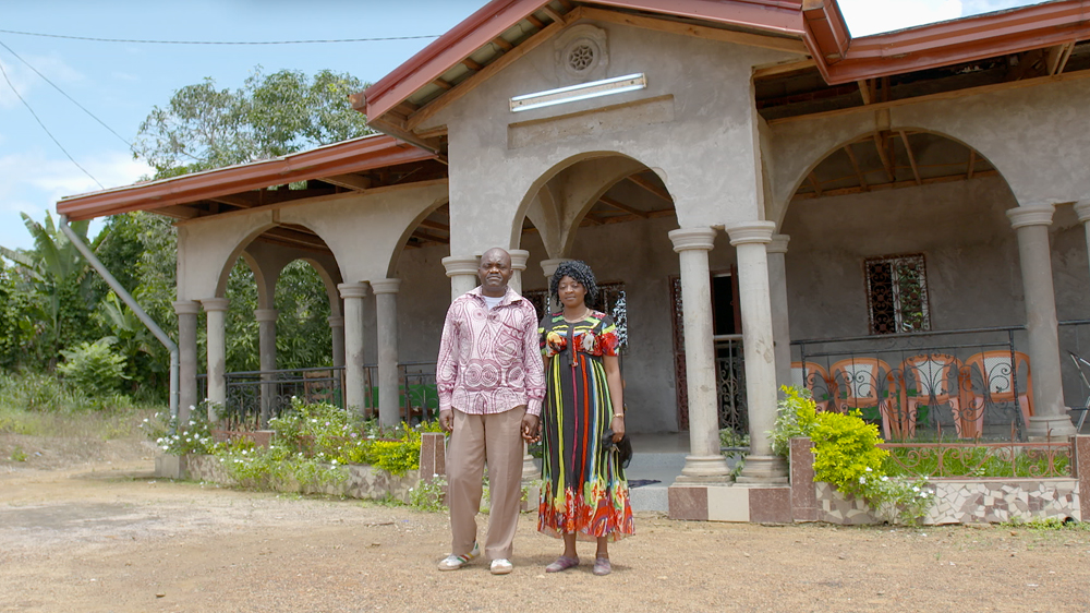 Jean-Paul Ndenga and his wife outside his home on his smallhold farm [Hugh Hartford / Al Jazeera]