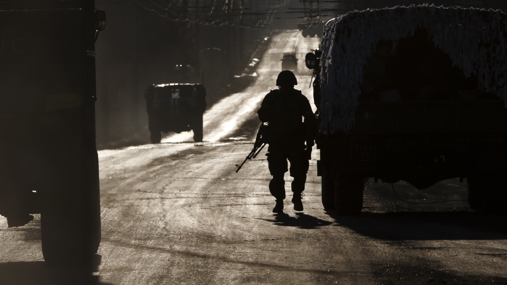 Ukrainian soldier stands next to a broken down vehicle outside Artemivsk
