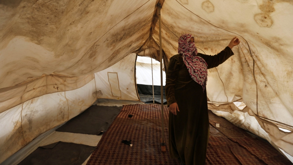 A Syrian refugee stands inside her tent which was affected by a heavy snowstorm at Al Zaatari refugee camp in the Jordanian city of Mafraq, near the border with Syria