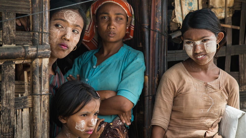 Rohingya women in the Sittwe camps wait for food distribution. While some aid is making it through, many medical relief agencies have been kicked out by the government [Jason Motlagh/Al Jazeera]