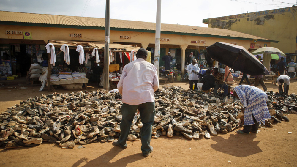 A man buys shoes from a street vendor in Gueckedou, the town where the Ebola outbreak began [Misha Hussain/Thomson Reuters Foundation]