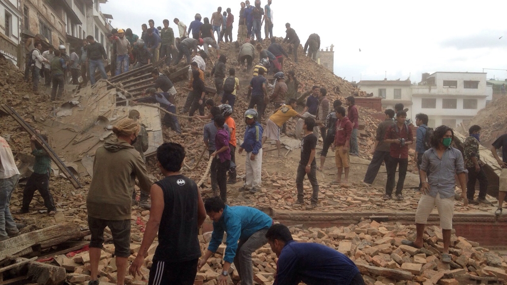 Volunteers help with rescue work at the site of a building that collapsed after an earthquake in Kathmandu [AP Photo]