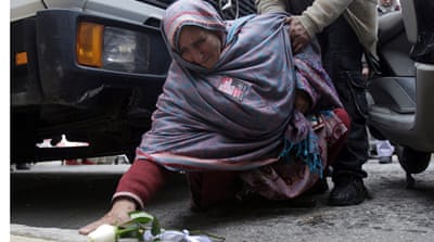 The mother of Sahzat Lukman lays flowers at the spot where her son was killed [EPA]