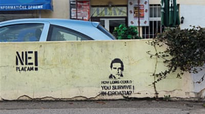 Graffiti on Zagreb street asks 'How long can you survive in Croatia?' [Yermi Brenner/Al Jazeera]