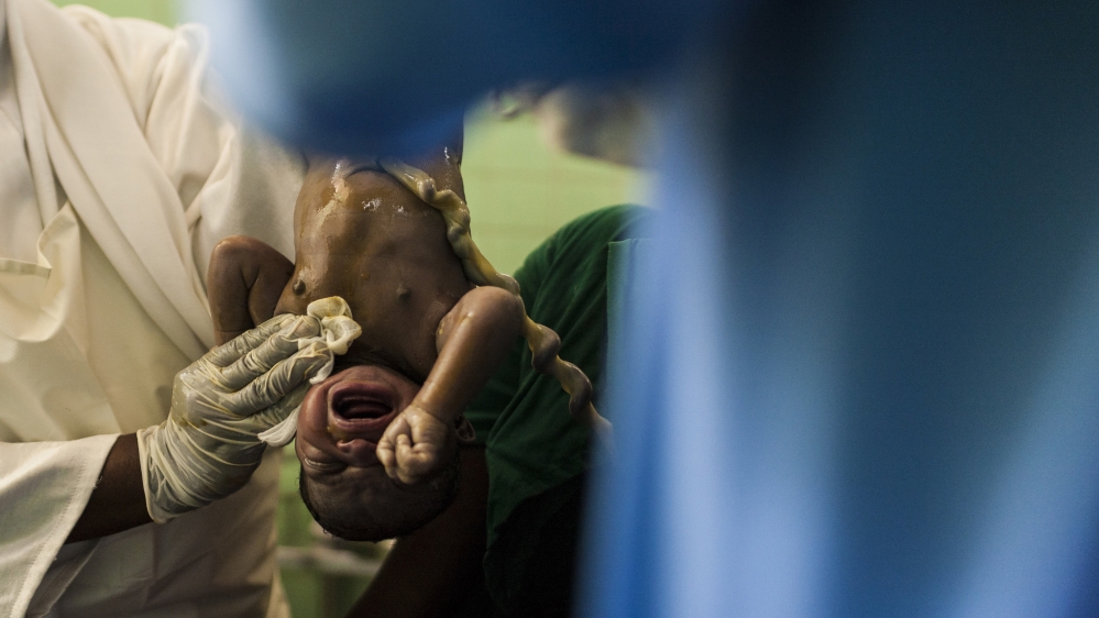 A midwife holds the son of Hajira Adan. He is her fourth child [Adriane Ohanesian] 