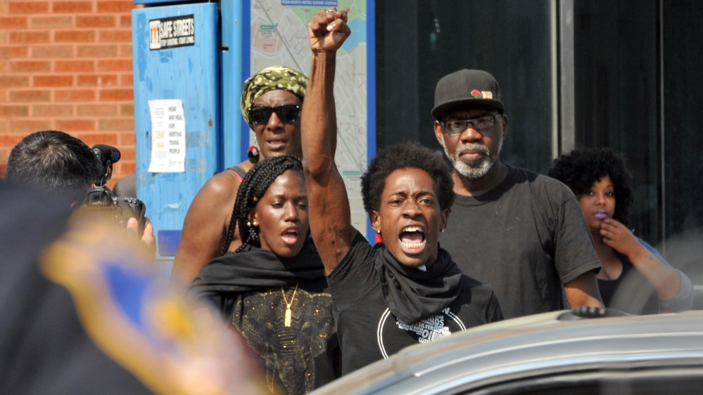 Protesters chant in front of police in Baltimore [AP]