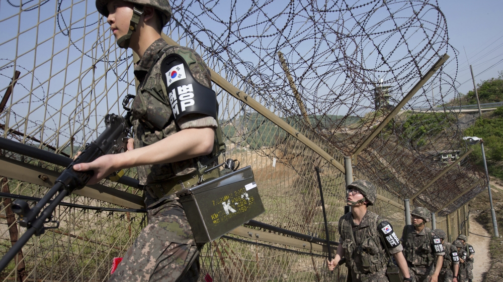 South Korean army soldiers patrol along the barbed-wire fence at the demilitarized zone (DMZ) in Cheorwon, South Korea, on May 13, 2014 [Lim Byung-shik/Yonhap, AP]