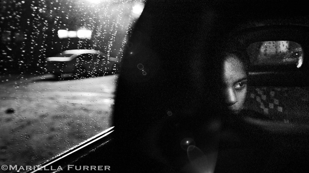 Thirteen-year-old Jennifer sits in a police car after being rescued during a night raid. Abducted in Durban, she had been brought to Johannesburg and forced into the sex trade. She said that although she had not been made to work yet, the pimp and another man spiked her drink and raped her. Germistan, November, 2004 [Mariella Furrer]
