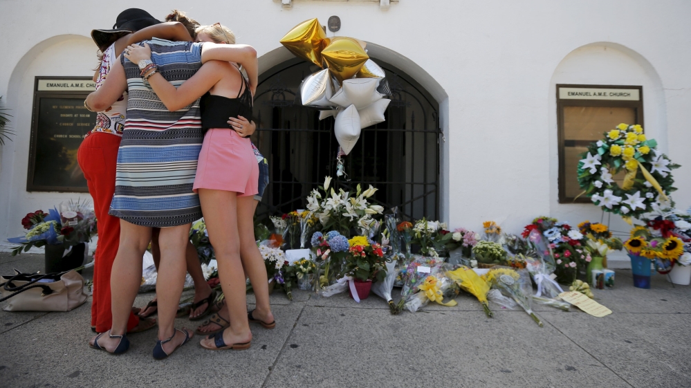 Mourners hug after praying outside the Emanuel African Methodist Episcopal Church in Charleston