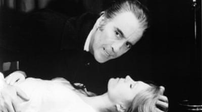 Christopher Lee about to bite Joanna Lumley in a scene from a 1973 film [Getty]