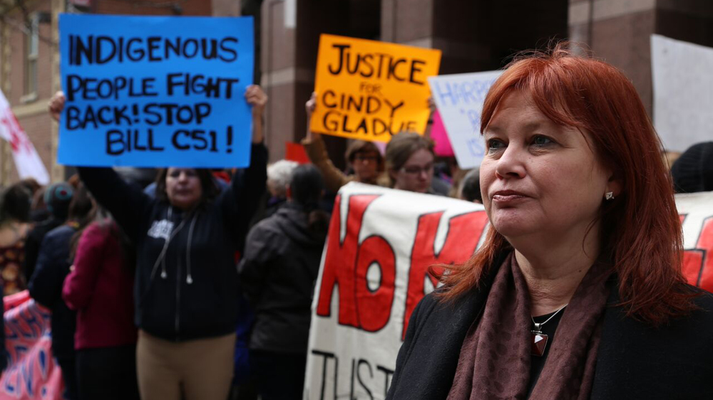 Reporter Sarah Spiller joins in a rally calling for the granted safety of indigenous women [Karim Shah / Al Jazeera]