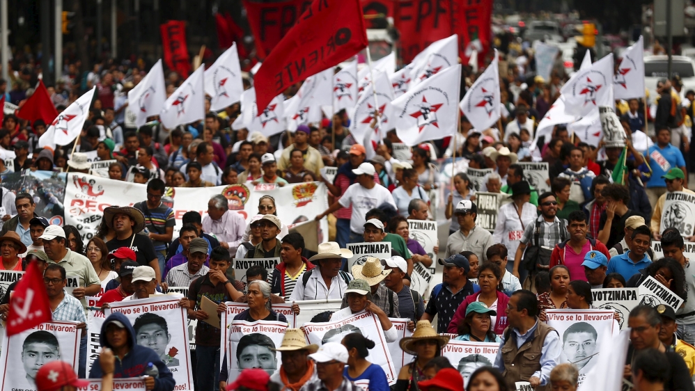 Demonstrators march during a protest to mark the nine-month anniversary of the Ayotzinapa students'' disappearance in Mexico City