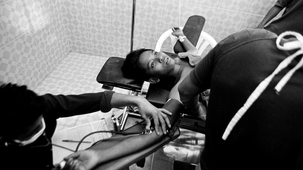 This 14-year-old landmine victim is having his gangrene-infected leg amputated with a blunt saw and a local anaesthetic. He winced at times during the operation but did not scream [Jack Picone]