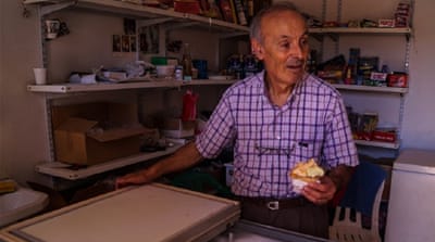 Joseph Masrouaa serves a traditional, stringy type of ice cream to tourists [Federica Marsi/Al Jazeera]