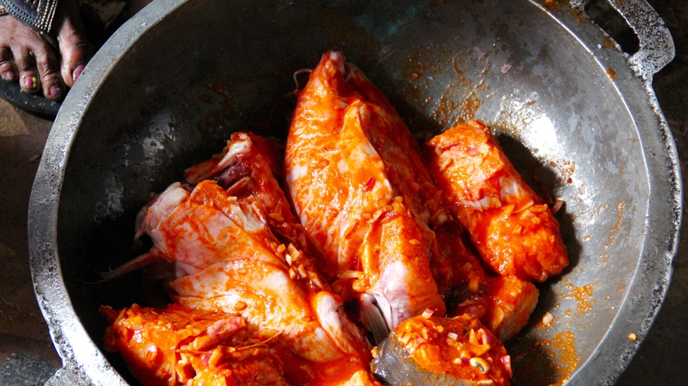 For Calabar food to taste good, it needs to be fresh, says Golda, who daily buys ingredients such as goat meat and catfish - pictured here in a pepper marinade - from various open-air markets [Femke van Zeijil/Al Jazeera]