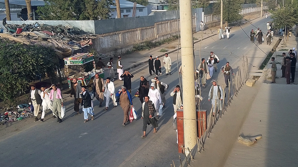 
Taliban prisoners walk on a street after their comrades released them from the main jain in Kunduz city [AP]
