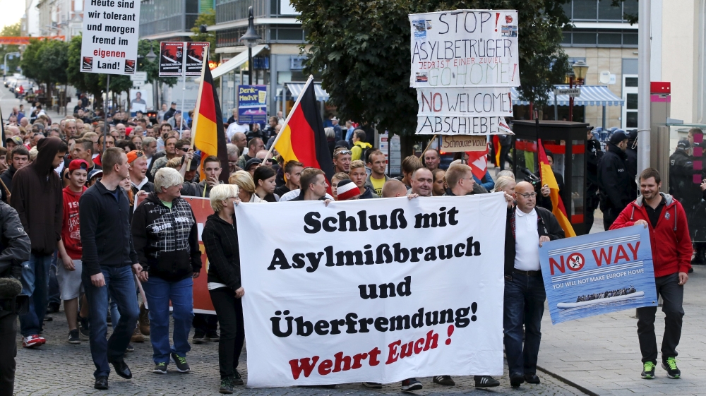 Supporters of the far-right National Democratic Party hold banners and German flags during a march in Riesa, Germany