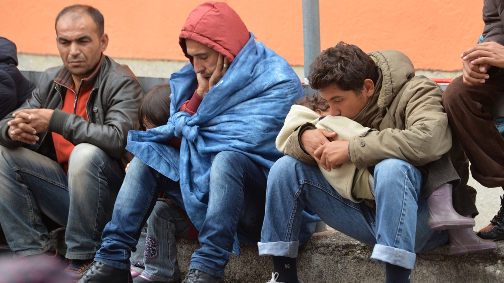 Migrants sit on a platform at the rail station in Freilassing, Germany