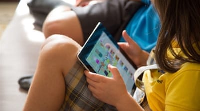 Girl watching cartoons online with an iPad tablet [Getty]