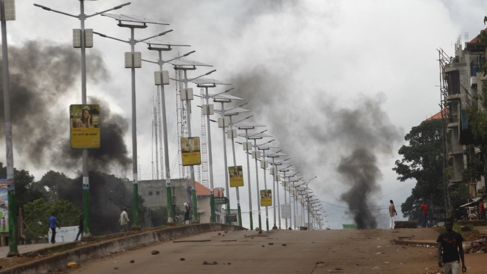 Smoke billows on a street in Bambeto during a protest after opposition candidates called on Monday for the results of the election to be scrapped due to fraud, in Conakry