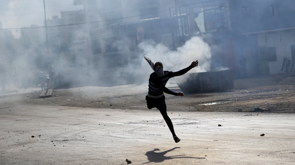 Palestinian protester hurls stones at Israeli troops during clashes near the Jewish settlement of Bet El, near the West Bank city of Ramallah