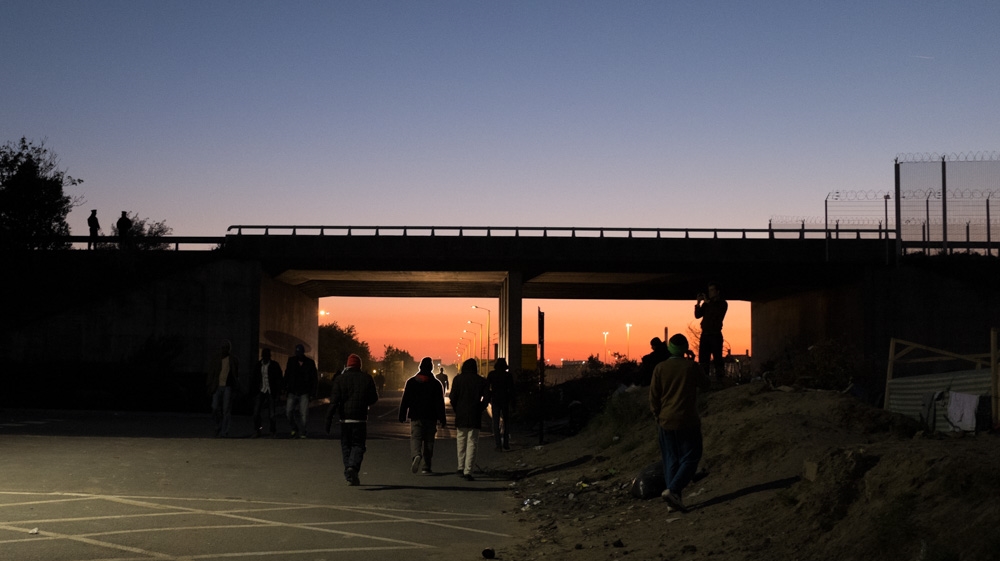 There is little to do once darkness falls in the poorly-lit Calais Jungle if you aren't planning to try to cross to the UK that night [Jack Crosbie/Al Jazeera]